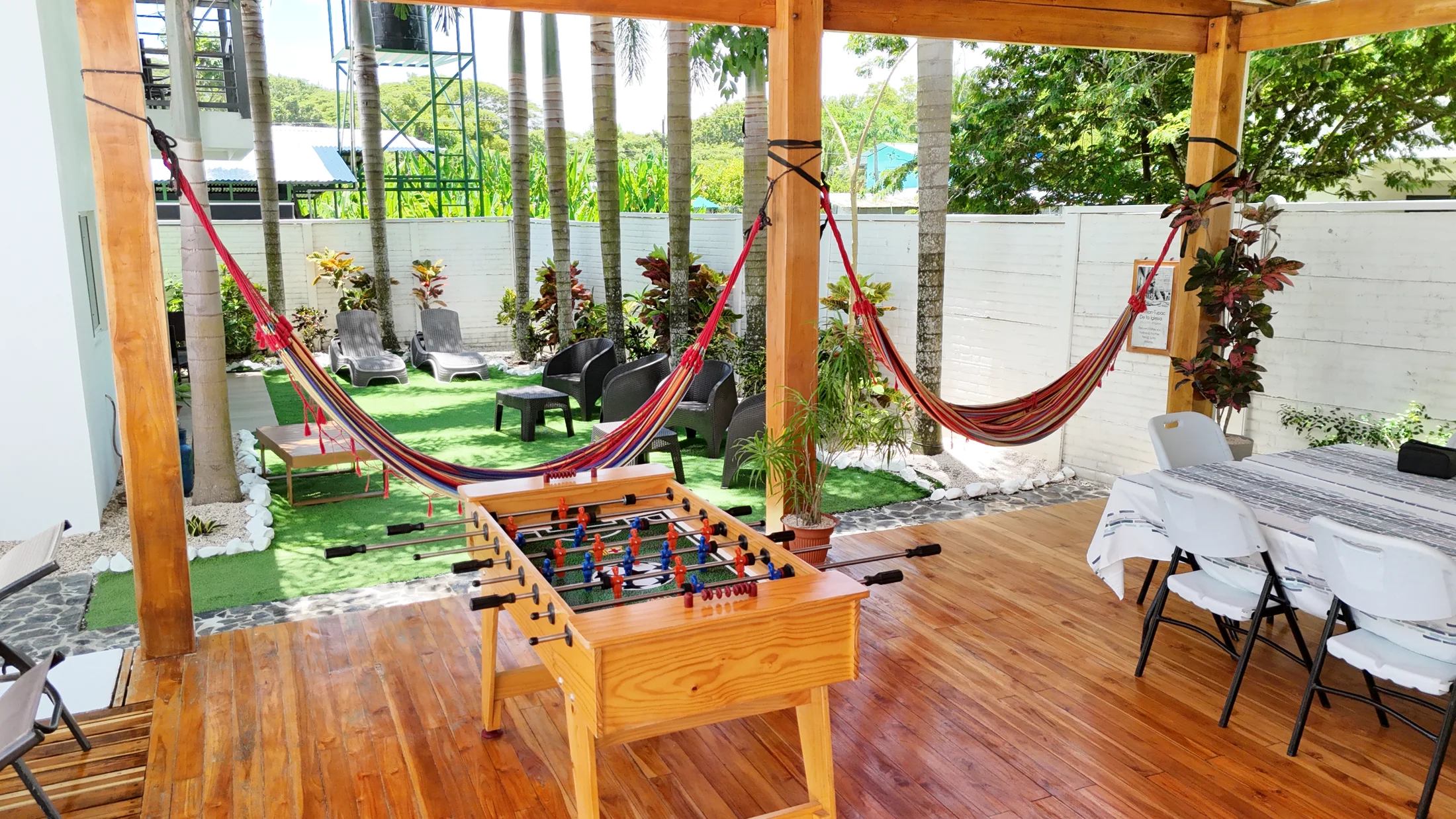 Shared gazebo with hammocks, foosball table and tropical garden seating