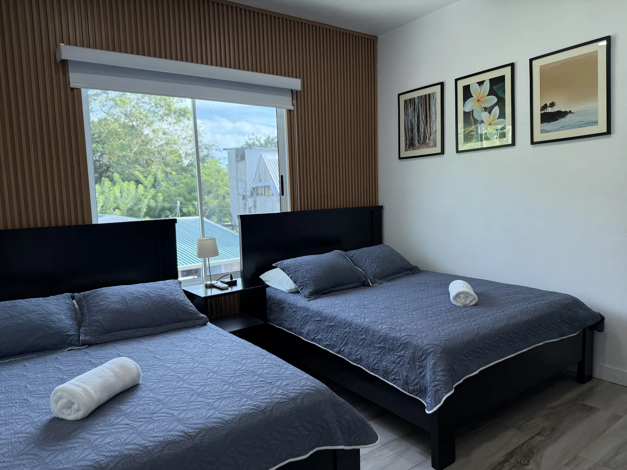 Bright guest bedroom with two beds and leafy views