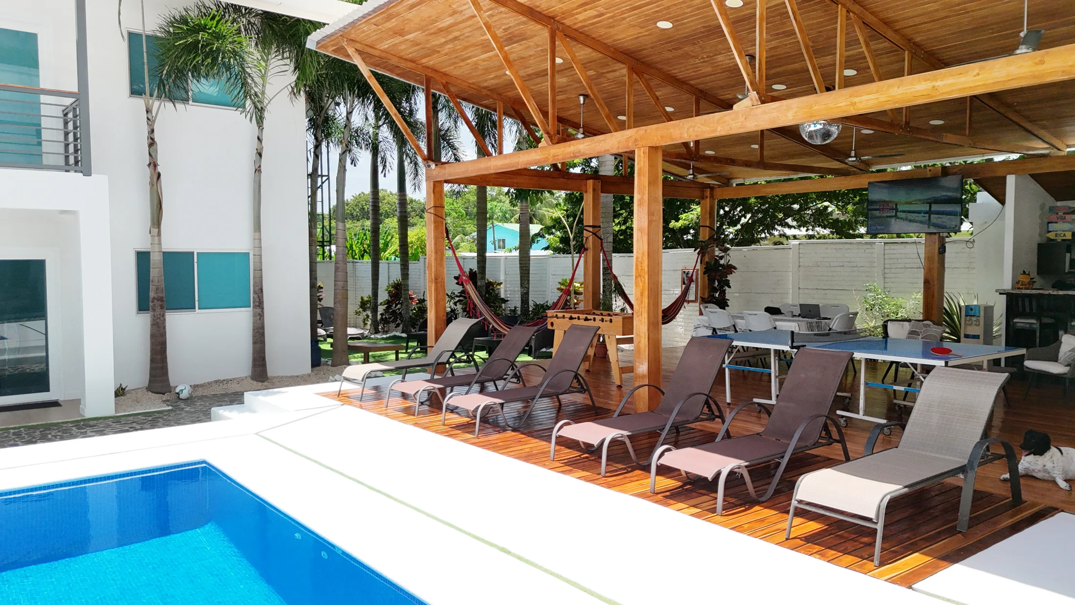 Poolside loungers beneath the spacious teak entertainment gazebo